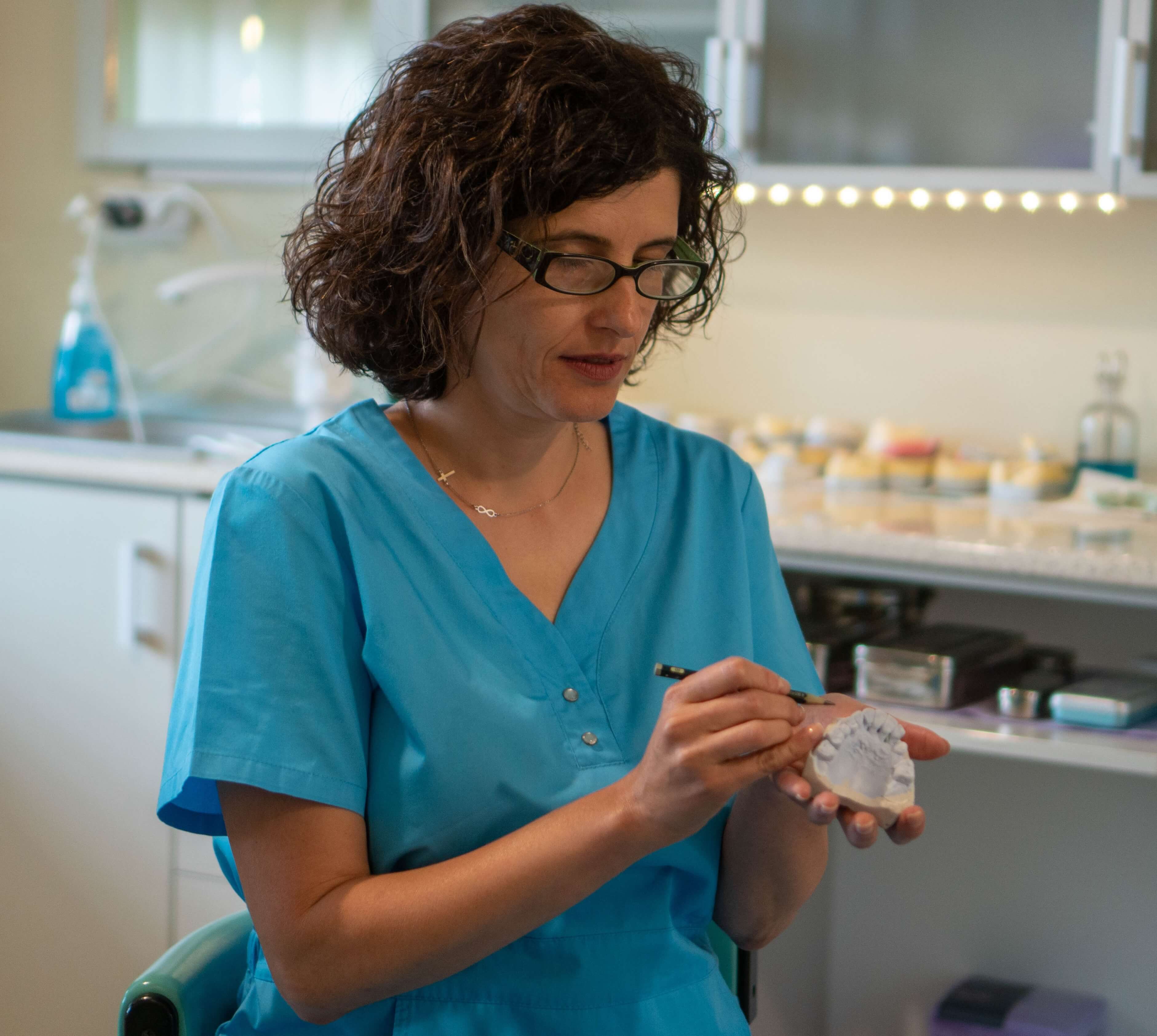 Medic stomatolog Dr. Meda Munteanu realizând un tratament dentar profesional în cabinetul din București